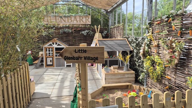 A wooden signpost with 'Little Glenbarr Village' and a small wooden structure resembling a house. - The House at Glenbarr (Tarbert)