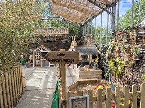 A wooden signpost with 'Little Glenbarr Village' and a small wooden structure resembling a house. - The House at Glenbarr (Tarbert)