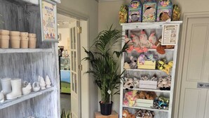 A room with a white door, a shelf with pottery, a plant, and a shelf with stuffed animals. - The House at Glenbarr (Tarbert)
