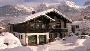 A chalet-style building with a sloped roof, large windows, and a sign indicating it is a restaurant.