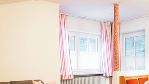 Un salon comprenant un canapé, une table basse, un banc en bois et un radiateur.
