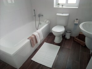 A bathroom with a bathtub, toilet, and sink.