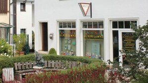 Een wit gebouw met een rode pannendak, een klokkentoren en een bord met de tekst 'Hotel Brana'.