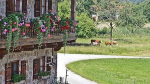 A rustic stone building with wooden balconies and flower boxes.