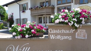 A building with a sign reading "Gästehaus Wolfgang" and "Willkommen" welcoming visitors. - Gästehaus Wolfgang (Ruhpolding)