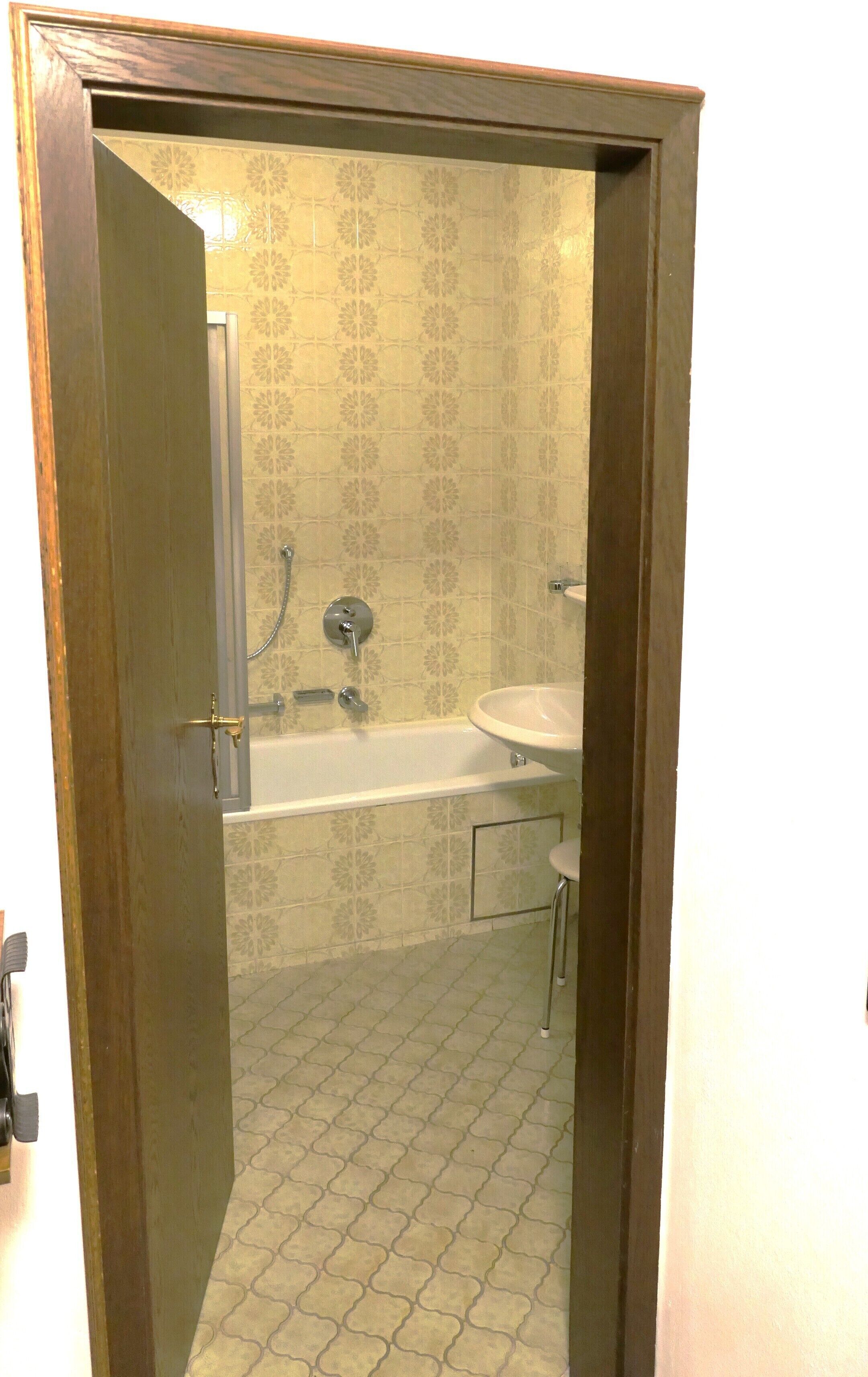 Une salle de bain avec une baignoire, un lavabo et des carreaux décorés.