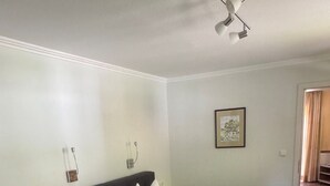 Un dormitorio con cama, mesitas de noche, alfombra y lámpara del techo.
