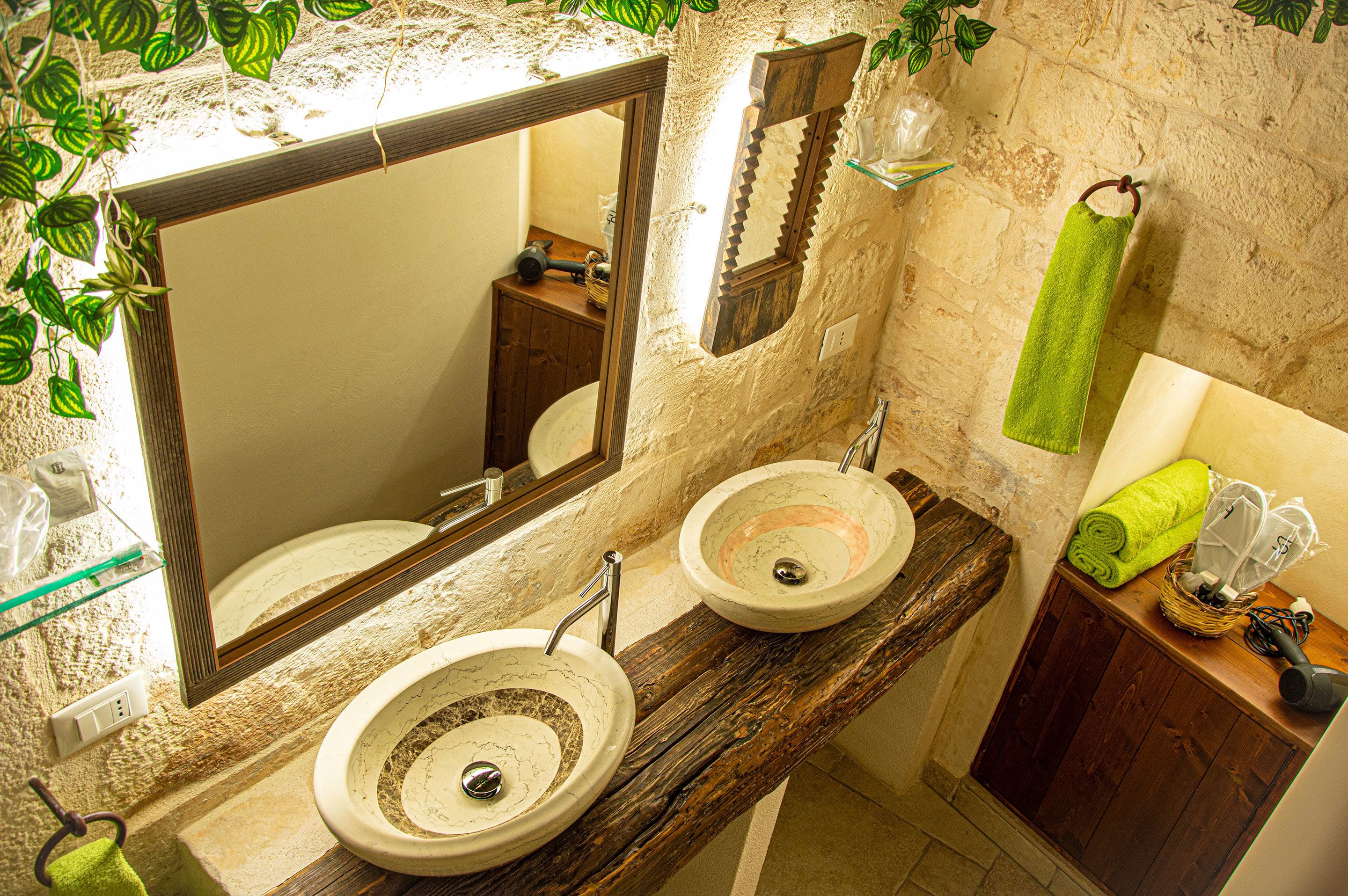 Ein Badezimmer mit zwei Waschbecken, einem großen Spiegel und einer Holzwaschkommode.