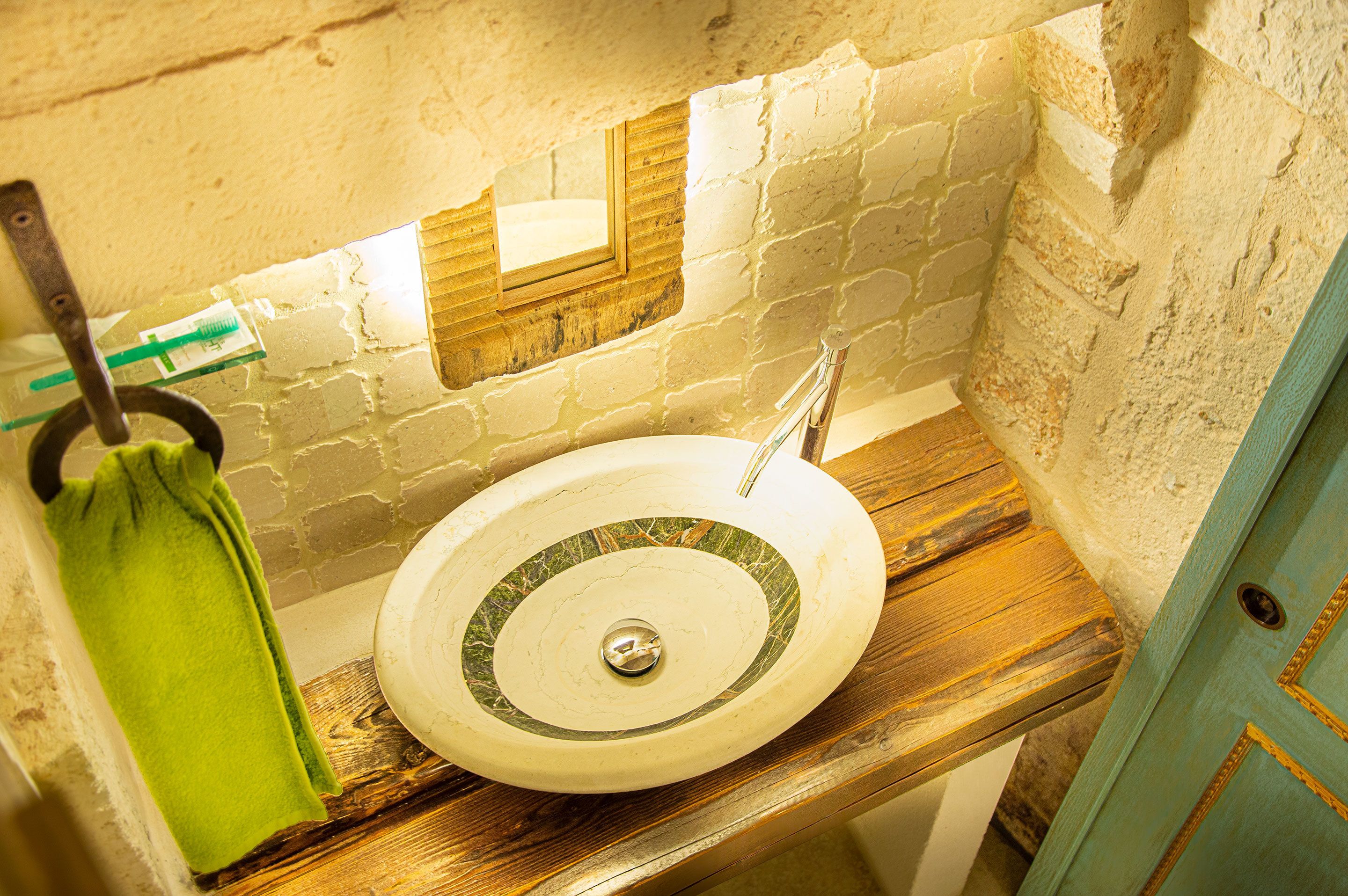 Un baño con lavamanos, espejo y perchero.