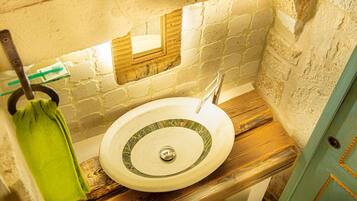 Un baño con lavamanos, espejo y perchero.
