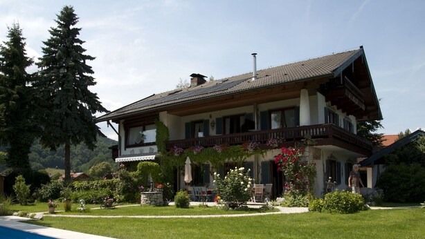 A two-story house with a swimming pool in the foreground. - 1. Fewo Friedenrath, 25 qm, 1-2 Pers., Wohn-Schlafraum, Westbalkon (Grassau)