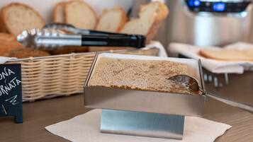 A buffet setup with a bread station, a sign, and a stainless steel appliance in the background.