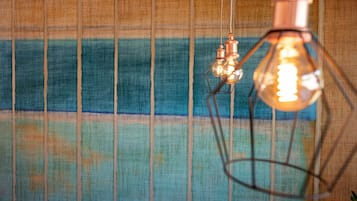Ein Zimmer mit strukturierter Wand und hängenden Leuchten.
