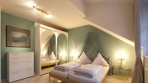 A bedroom with a bed, a wardrobe, a mirror, and a nightstand with a lamp. - Ferienwohnung Nr. 1 - "Panoramablick", 108 qm Obergeschoss, 1 separates Schlafzimmer (Bad Endorf)