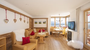 Ein gemütliches Wohnzimmer mit einer Couch, Sesseln, einem Esstisch und einem Kamin.