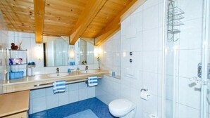 Un baño moderno con dos lavamanos, inodoro y ducha.