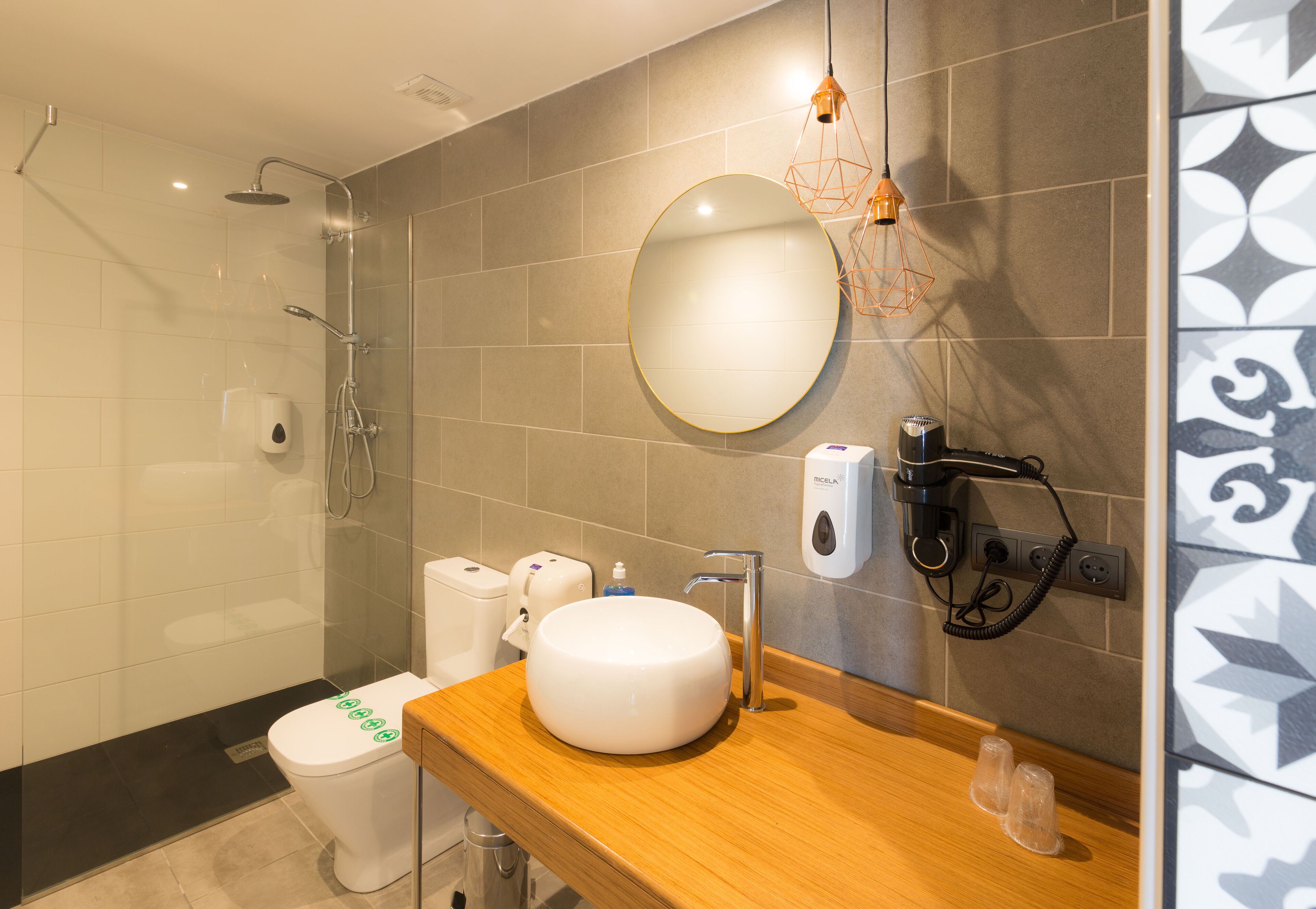 Un baño moderno con ducha, inodoro, lavabo y espejo.