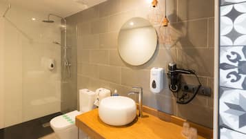 Un baño moderno con ducha, inodoro, lavabo y espejo.