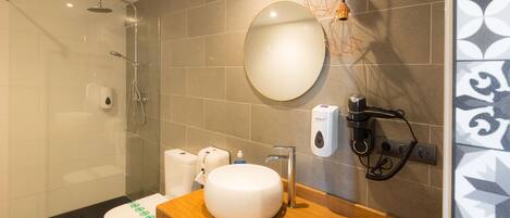 Ein modernes Badezimmer mit Dusche, Toilette, Waschbecken und Spiegel.