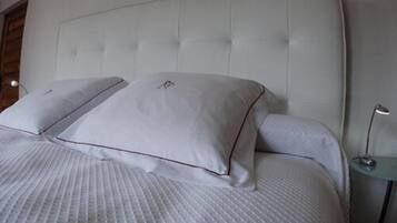 A neatly made bed with a tufted headboard and two pillows.
