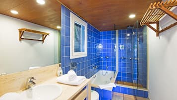 A bathroom with a wooden ceiling, a bathtub, a shower, and a sink.