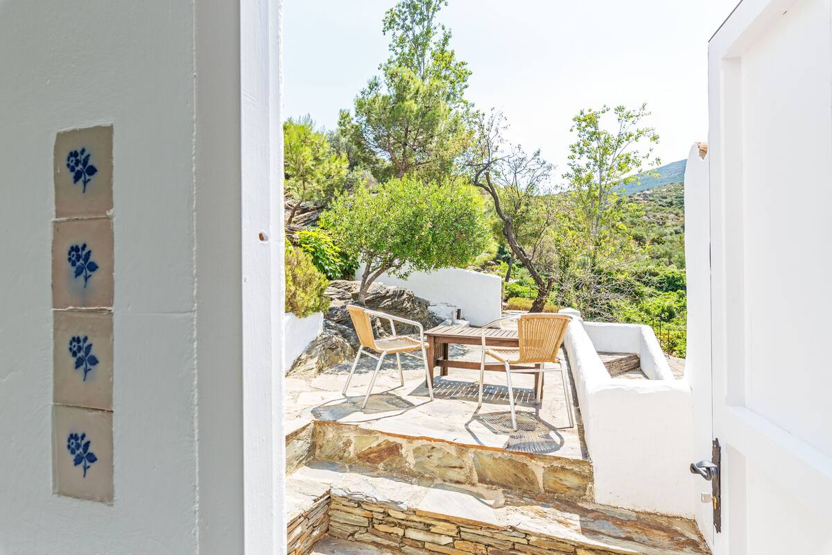 Un patio con suelo de piedra, una mesa y dos sillas.