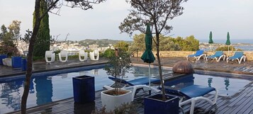Una piscina al aire libre, sillones reclinables de piscina