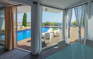 A balcony with a pool, outdoor seating, and a view of the sea. - Hotel Rec de Palau (Cadaqués)