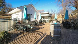 An outdoor patio area with tables and chairs, a barrel, and umbrellas. - Brinckerhoff Inn (Fishkill)
