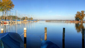 Eine ruhige Marina mit vertäuten Booten, einer Holzsteganlage und einem Zelt im Vordergrund.