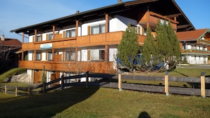 Un bâtiment en bois à deux étages, doté de balcons, avec une enseigne indiquant qu’il s’agit d’un restaurant, et une clôture en bois au premier plan.