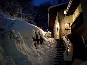 A snow-covered staircase leading to a building entrance at night.