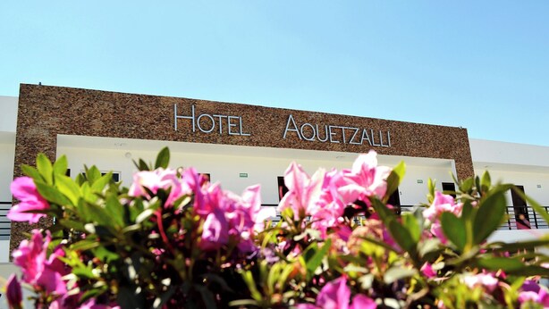 A hotel named 'Hotel Aquetzaalli' with a modern facade and a clear sky. - Hotel Aquetzalli (Yautepec)