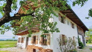 A white building with wooden shutters and a stone staircase leading to the entrance. - Vacation apartment Amelie, 70 sqm, balcony, 2 bedrooms (Schechen)