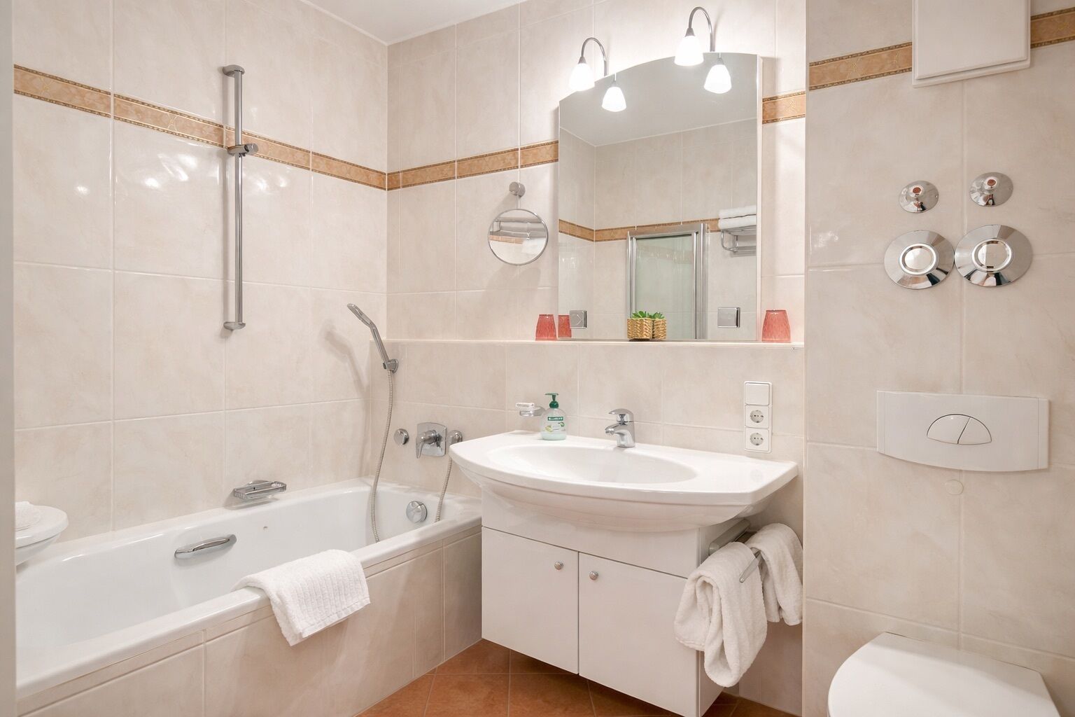 A modern bathroom with a bathtub, a sink, a mirror, and a shower.