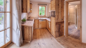Una cocina con armarios de madera, un microondas y un fregadero.