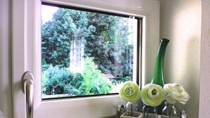 Ein Fenster mit Blick auf einen Garten und eine Tür.