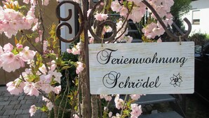 Schild mit der Aufschrift 'Ferienwohnung' und 'Schrödle', das auf eine Ferienunterkunft hinweist.