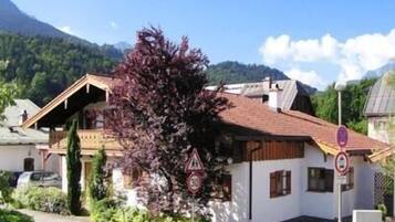 Ein traditionelles Chalet mit geneigtem Dach, Holzfassade und einem kleinen Balkon.