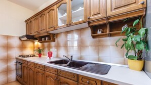 Una cocina con armarios de madera, un lavamanos doble y una estufa.