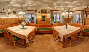 Enjoy meals in this traditional dining room with a central bench, two dining tables, and comfortable seating for all.