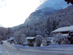 Winter wonderland setting with snow-covered buildings and a mountain backdrop.