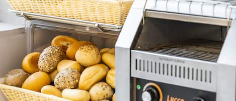 A bakery display with various baked goods in wicker baskets and a commercial toaster oven.