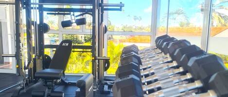 Un gimnasio con equipo de levantamiento de pesas y una banca.