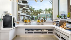 A modern kitchen with a coffee station, a bread display, and a view of the outdoor area. - Casas Pepe Apartments & Spa- Adults Only (San Bartolomé de Tirajana)