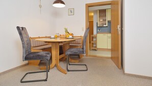 A dining area with a round table, four chairs, and a hanging light fixture. - gemütliche Ferienwohnung für 1-4 Personen mit großem Balkon und Bergblick (Wohnung 2) (Bayerisch Gmain)