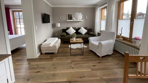 Un salon moderne comprenant un canapé, deux fauteuils, une table basse et une cheminée.