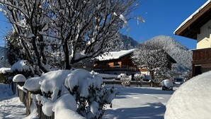 Un paysage enneigé avec un bâtiment en bois et une montagne en arrière-plan.
