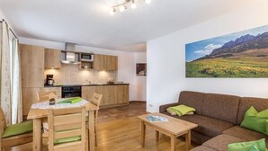 Un espace de vie compact comprenant une cuisine, un coin repas et un canapé.