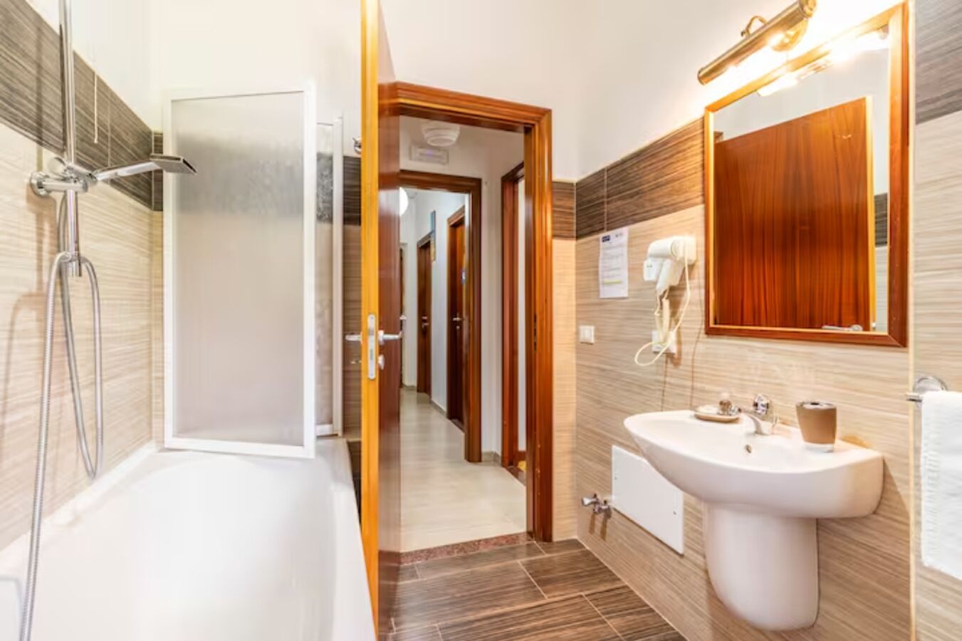 A modern bathroom with a shower, a sink, and a mirror.